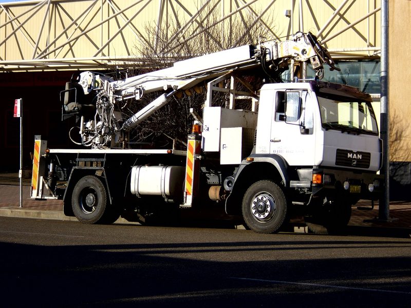 Truck-mounted crane and pole borer fitted to a rigid truck in Australia