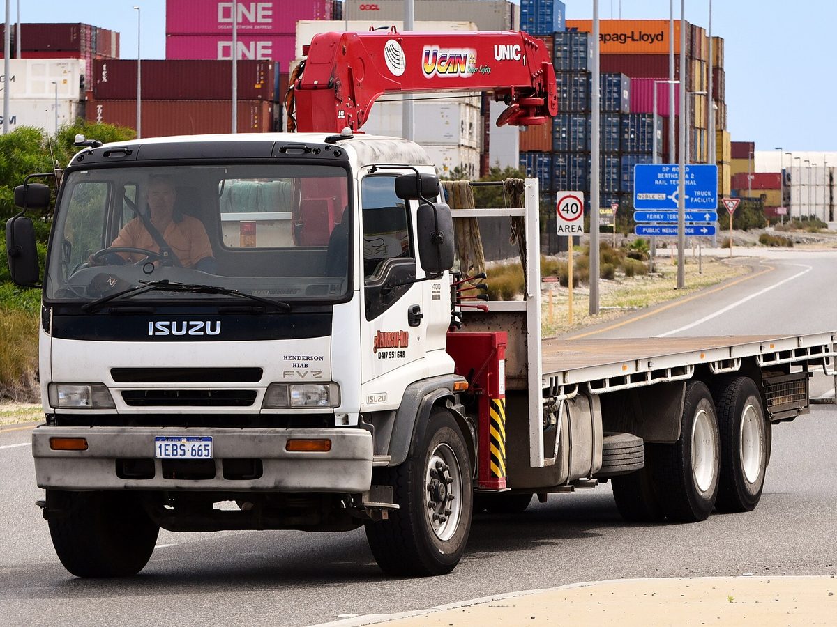 Isuzu F-Series flat tray truck with a crane, Western Australia