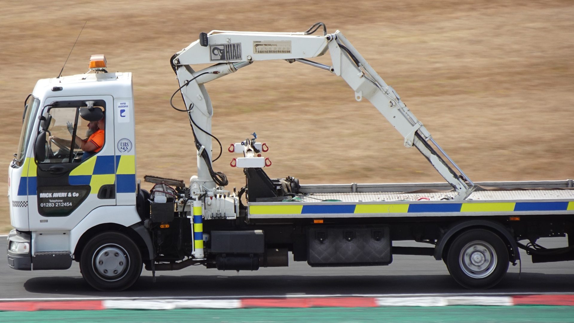 Tilt tray truck with a truck-mounted crane